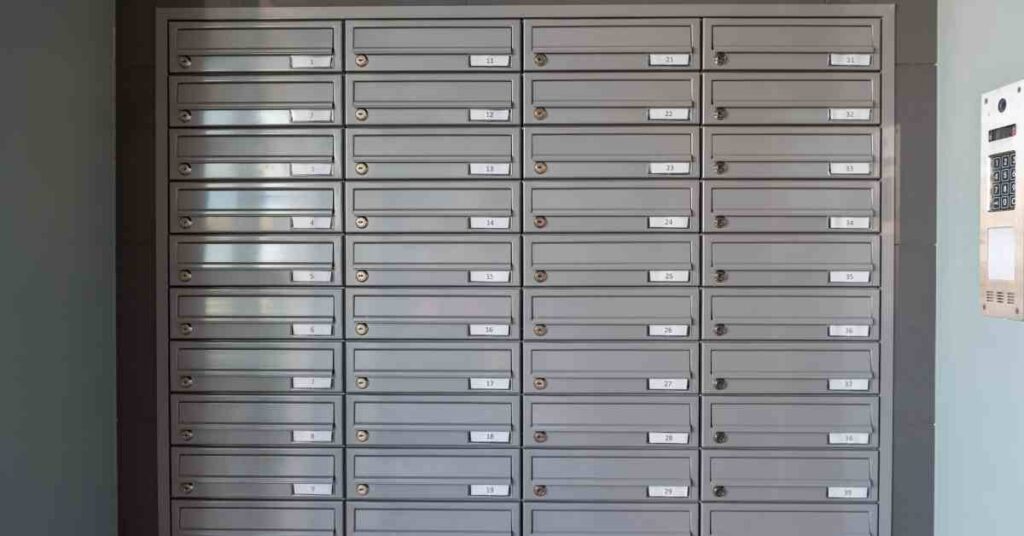 Building lobby with a series of grey horizontal mailboxes inset into the wall that is painted dark grey