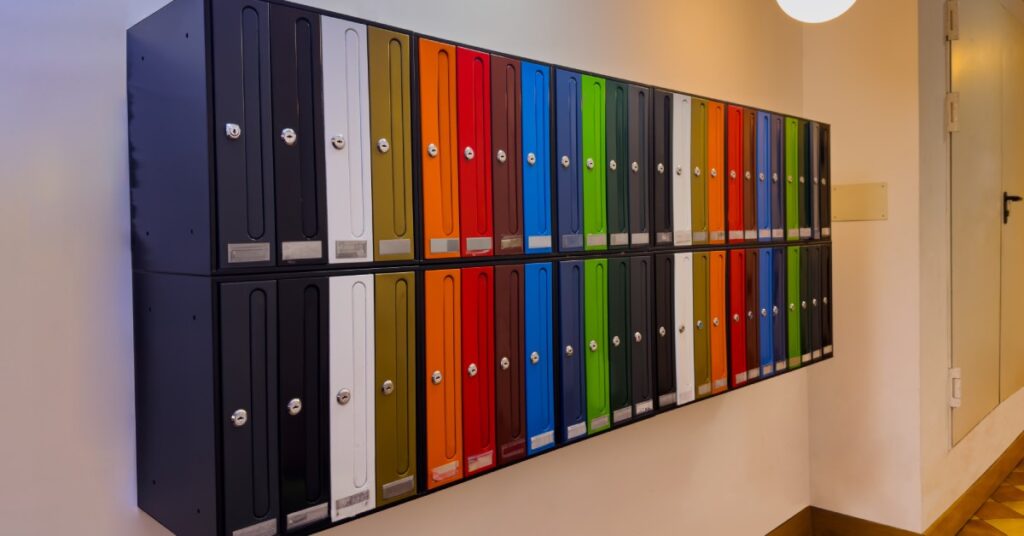 A wall-mounted cluster box unit with very colorful doors is set up in an elegant lobby with globe lights.
