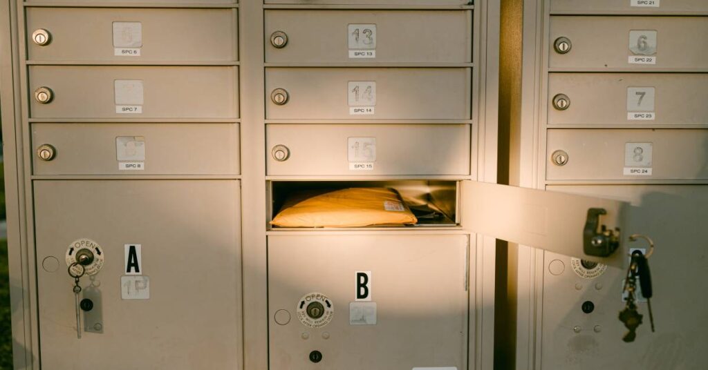 A closeup of a set of group mailboxes. There is only one unlocked compartment, opened to show pieces of mail inside.