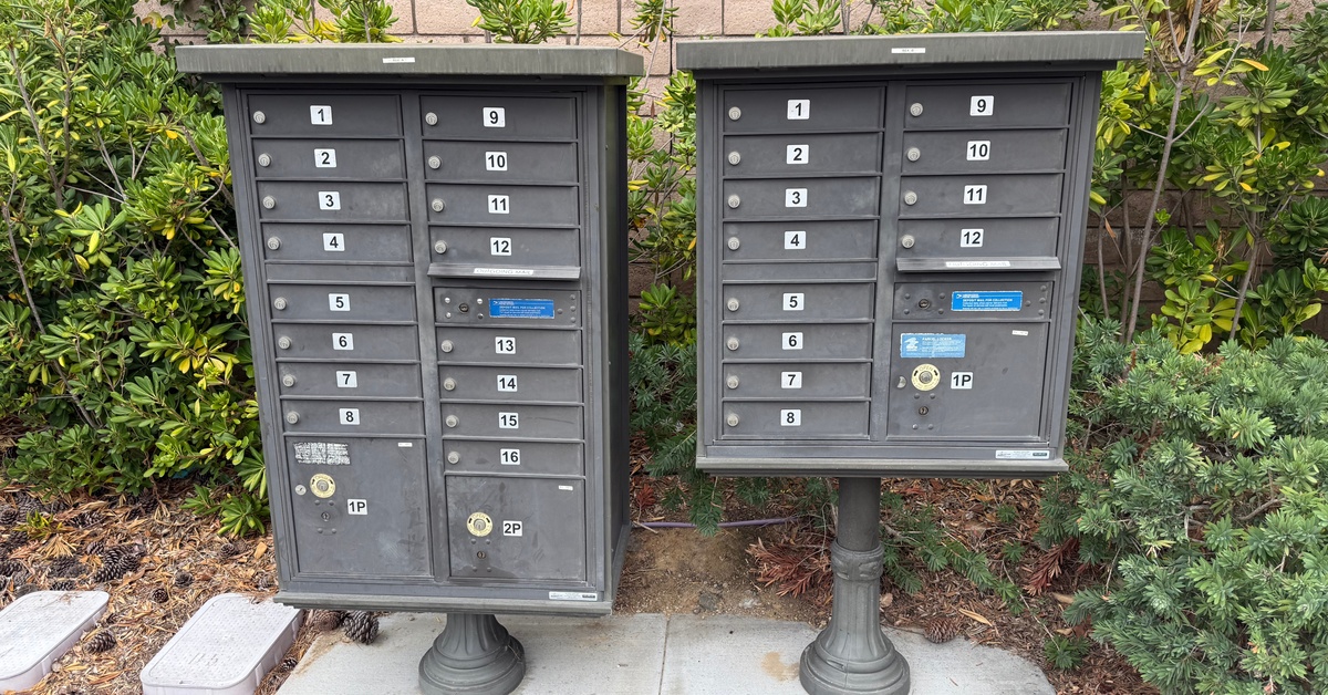 Two mailbox units next to each other. Each one has two vertical rows of mailboxes, each box having its own number.