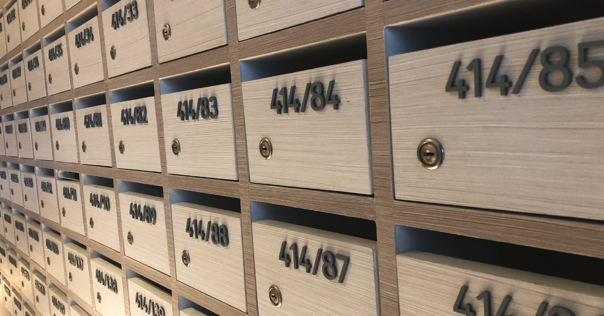 There are rows of wooden mailboxes, and each one has a different number and a keyhole.